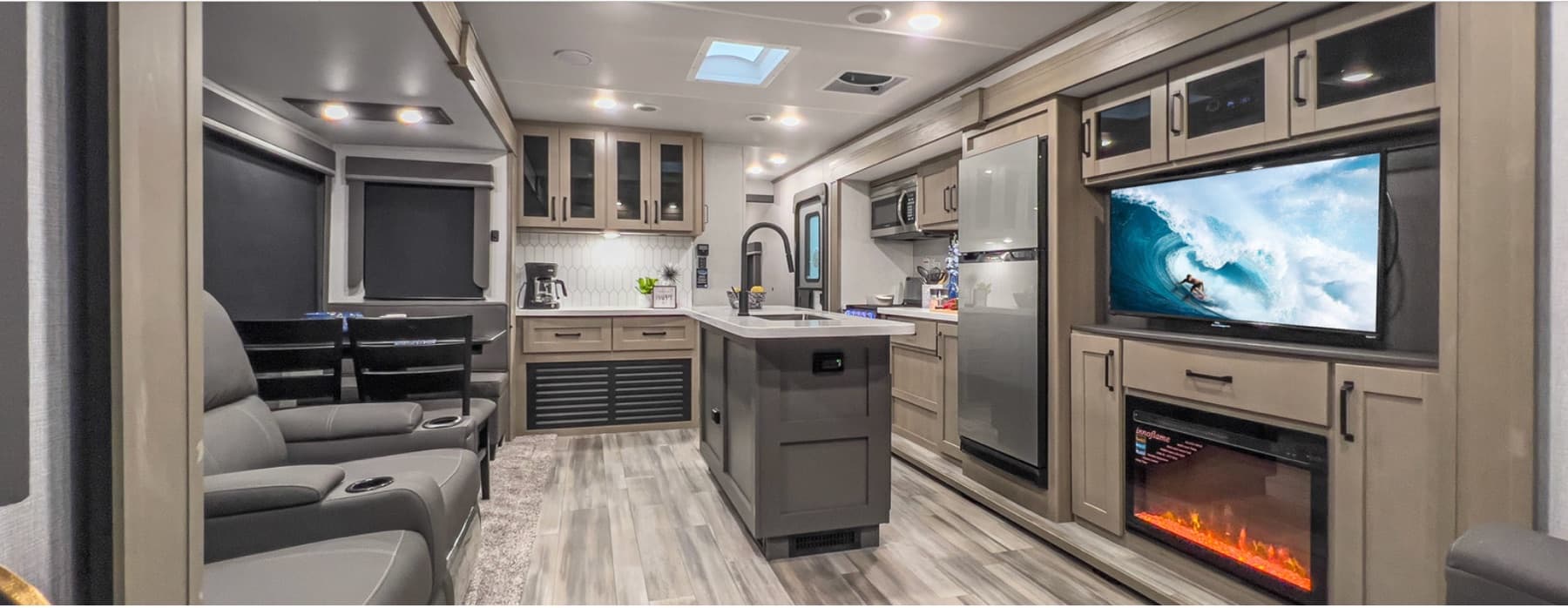 Galley view — recliners, kitchen island, fireplace, and 40-inch TV